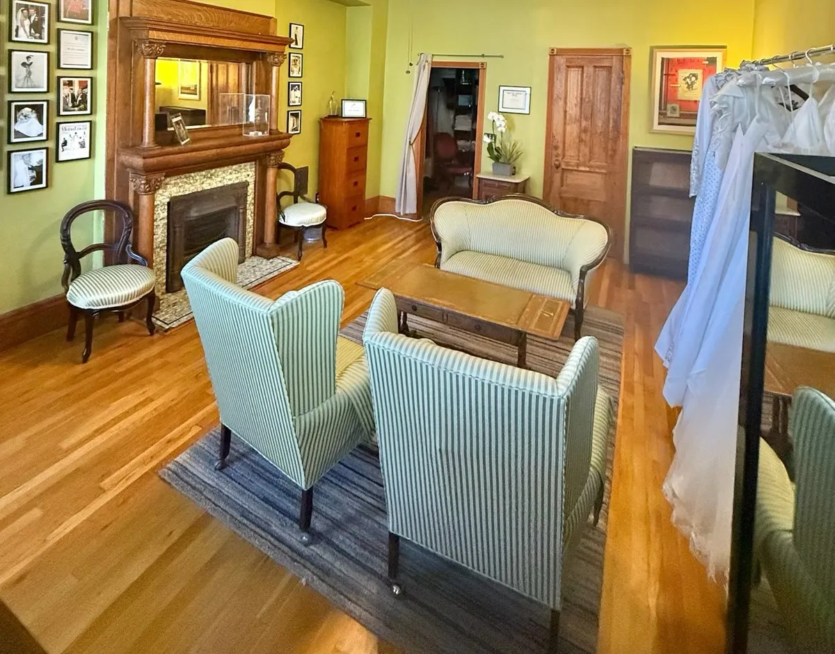 The Kosibah salon: striped wingback chairs and a settee facing a carved oak fireplace.
